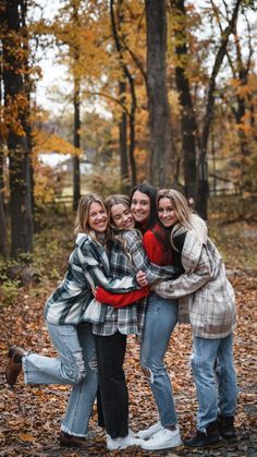 four friends hugging in the fall leaves