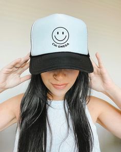 a woman with long black hair wearing a white and black hat that says aloha gang