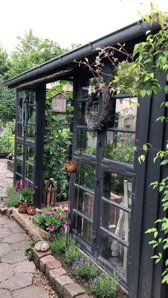 a black building with lots of windows and plants