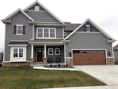 a large gray house with two garages in the front yard