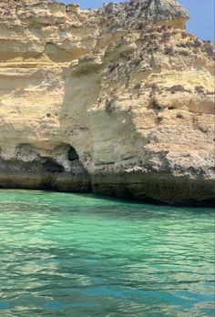 the water is crystal blue and clear with some cliffs in the backgrouds