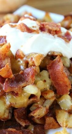 a close up of a plate of food with bacon and cream on top, sitting on a table