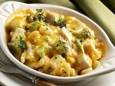 a white bowl filled with macaroni and cheese covered in broccoli