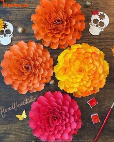 paper flowers are arranged on a wooden table