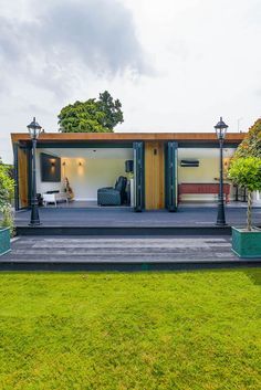 a modern house with an open living area and large grass field in front of it