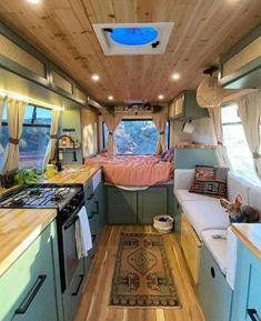 the interior of an rv with wood flooring and blue cabinets, including a stove top oven