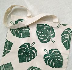 This organic cotton tote bag was printed by hand from hand-carved blocks.  Totes make great gifts! Hot tip: Use this monstera tote bag as an earth-friendly and practical gift gift bag, and fill it with other small goodies for your favorite plant-loving friend. CARE INSTRUCTIONS: Machine Wash in Cold Water Tumble Dry on Low Heat Iron on Reverse Green Eco-friendly Canvas Tote Bag, Green Eco-friendly Tote Canvas Bag, Eco-friendly Hand Printed White Canvas Bag, Green Handmade Cotton Canvas Bag, Handmade Green Cotton Canvas Bag, Eco-friendly Hand Printed Canvas Bag For Daily Use, Green Canvas Bag With Eco-friendly Ink As Gift, Eco-friendly Hand Printed Rectangular Canvas Bag, Eco-friendly Hand Printed Canvas Bag For Everyday Use