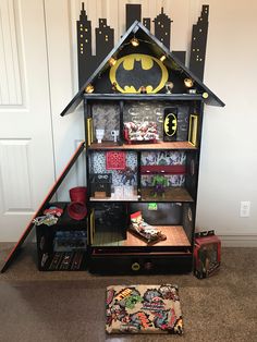 a doll house with batman decorations on the top and bottom floor, in front of a door