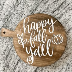 a wooden cutting board with the words happy fall y'all written in white on it