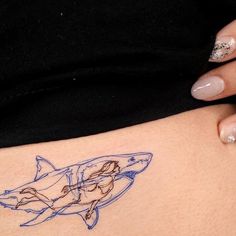 a woman's stomach with a drawing of a shark on the side of her body