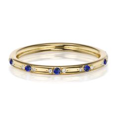 a yellow gold ring with blue sapphires and diamonds