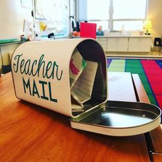 an open mailbox sitting on top of a wooden table