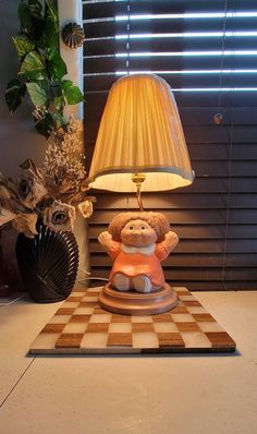 a lamp sitting on top of a table next to a teddy bear figurine