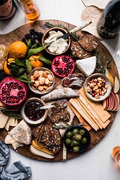 a wooden platter filled with cheese, crackers, nuts and other food items