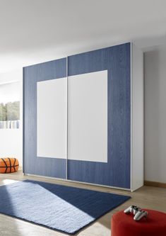 a blue and white bedroom with a basketball ball on the floor next to two cabinets