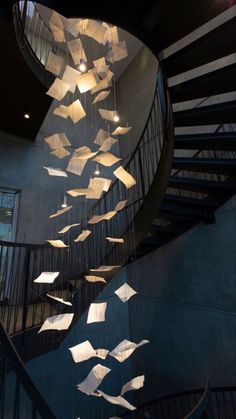 a spiral staircase with paper flying from it