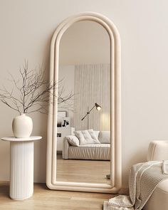 a large white mirror sitting on top of a wooden floor