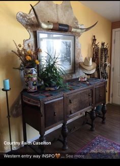 a wooden table topped with lots of plants and vases next to a wall mounted mirror