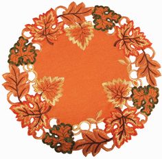 an orange doily with leaves and flowers in the shape of a heart on a white background