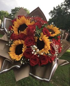 a bouquet of sunflowers and red roses on display