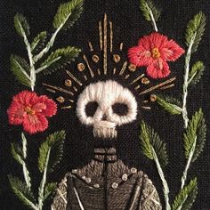 a close up of a piece of art with flowers on it and a skull in the middle