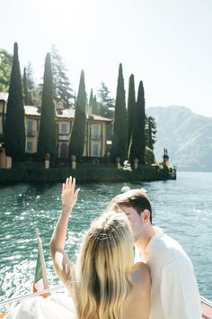 a man and woman riding on the back of a boat