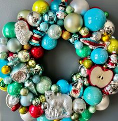 a christmas wreath with ornaments hanging on the wall