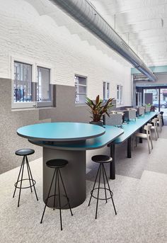 an empty conference room with blue tables and stools