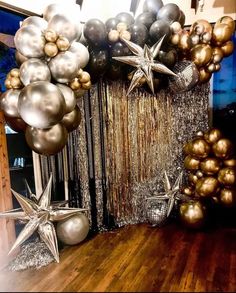 balloons and streamers are hanging from the ceiling in front of a star - shaped curtain