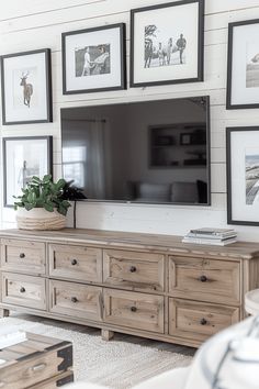 a living room with pictures on the wall and a large flat screen tv mounted above it