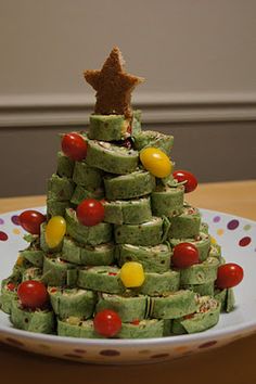 a small christmas tree made out of matchbox cookies on a white and red plate