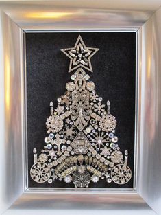 a christmas tree made out of beads in a silver frame with a star on top