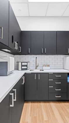 a kitchen with gray cabinets and white counter tops