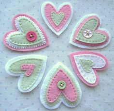 some pink and white felt hearts on a table