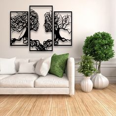 a white couch sitting next to two vases on top of a hard wood floor