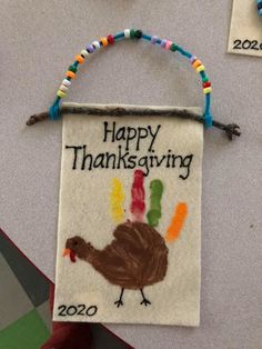 a handmade happy thanksgiving sign with a turkey on it's front and the words happy thanksgiving written in multicolored beads