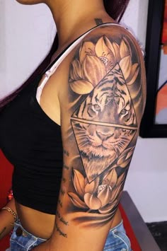 a woman with a tiger and flower tattoo on her arm is looking at the camera