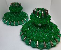 two green beaded purses sitting on top of a white table