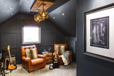 a living room with two chairs, a guitar and a lamp hanging from the ceiling