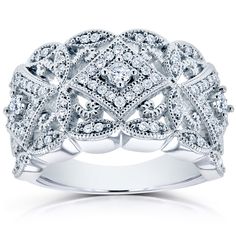 a white gold ring with diamonds on the sides and an intricate design in the middle