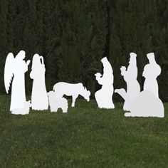 the silhouettes of people and dogs are in front of trees