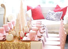 the table is set up with pink and gold decorations, candles, and candy canes