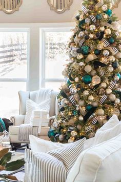 a christmas tree in the corner of a living room with blue and gold ornaments on it