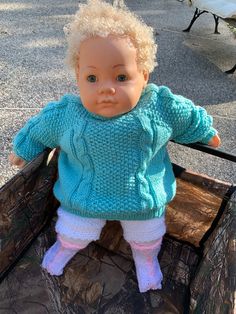 a baby doll sitting in a wagon on the ground