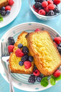 two slices of pound cake with berries and raspberries on the plate next to each other