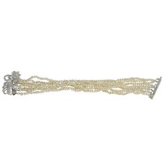 This vintage baroque cultured pearl and diamond bracelet is circa 1950. The seven strand pearl bracelet features a 14 karat white gold bow clasp with 116 total diamonds at 3.19 carat total weight VS2-SI1 clarity I color with one emerald cut, 14 round cut, 87 single cut and 14 baguettes. The pearl and diamond bracelet measures 7.25″ in length. This vintage pearl diamond bracelet is appraised at $9,918. Item #MICO 832 Formal White Baroque Pearl Bracelets, White Baroque Pearl Drop Bracelet, Luxury White Baroque Pearl Bracelets, Luxury Baroque Pearl Bracelet, Luxury Vintage Pearl Bracelet, Solvang Ca, 1 Carat Diamond Ring, 1950s Bracelet, Diamond Wedding Sets