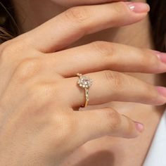 a close up of a person wearing a ring with a flower on the middle of it