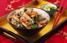 a bowl of food with chopsticks on a tray