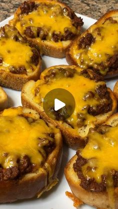 several pieces of bread with cheese and chili on them sitting on a white platter