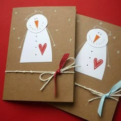 two brown cards with snowmen on them tied to twine and sitting next to each other